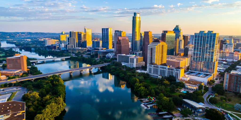 Austin Texas USA sunrise skyline cityscape over Town Lake or Lady Bird Lake with amazing reflection. Skyscrapers and Texas capital building in distance you can see the entire city during summer