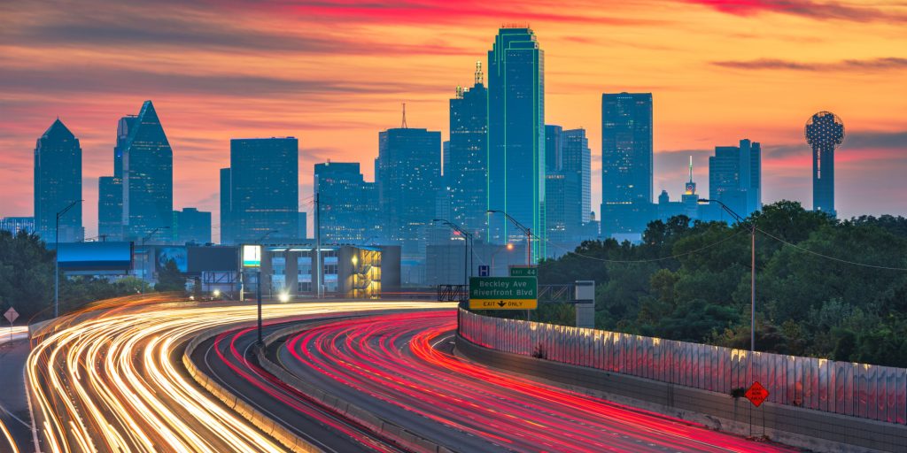 Dallas, Texas, USA downtown skyline and highway at dawn.