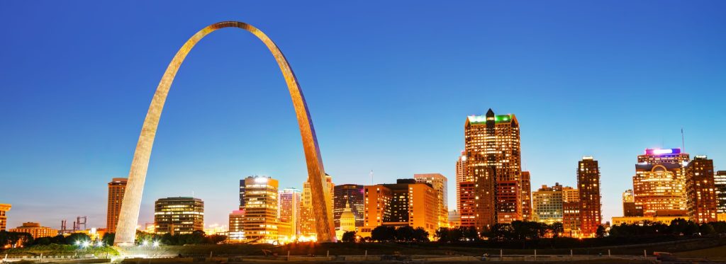 Downtown St Louis, MO with the Old Courthouse and the Gateway Arch at sunset