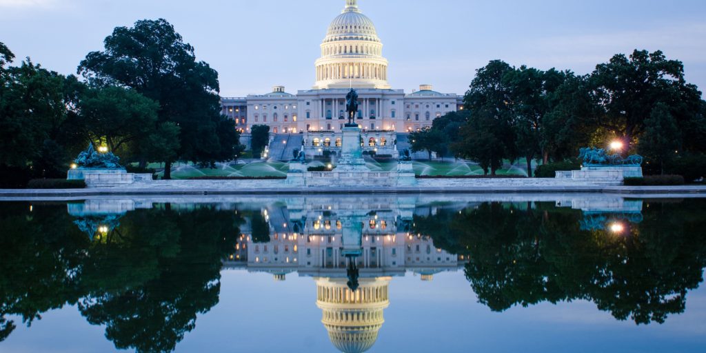 Washington DC, US Capitol Building in a cloudy sunrise with mirror reflection